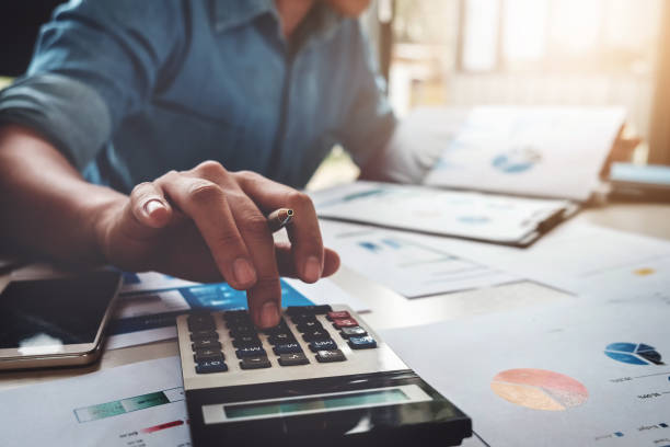 Financial advisor sat at his office desk working out figures on a calculator